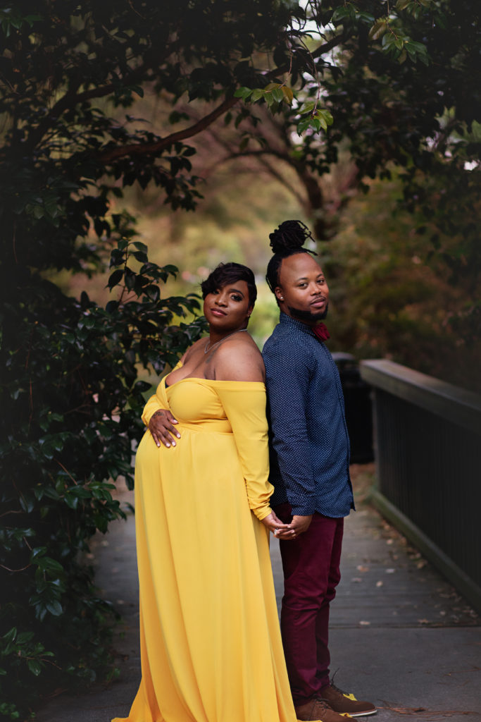 pregnant couple stand back to back glencairn garden maternity session