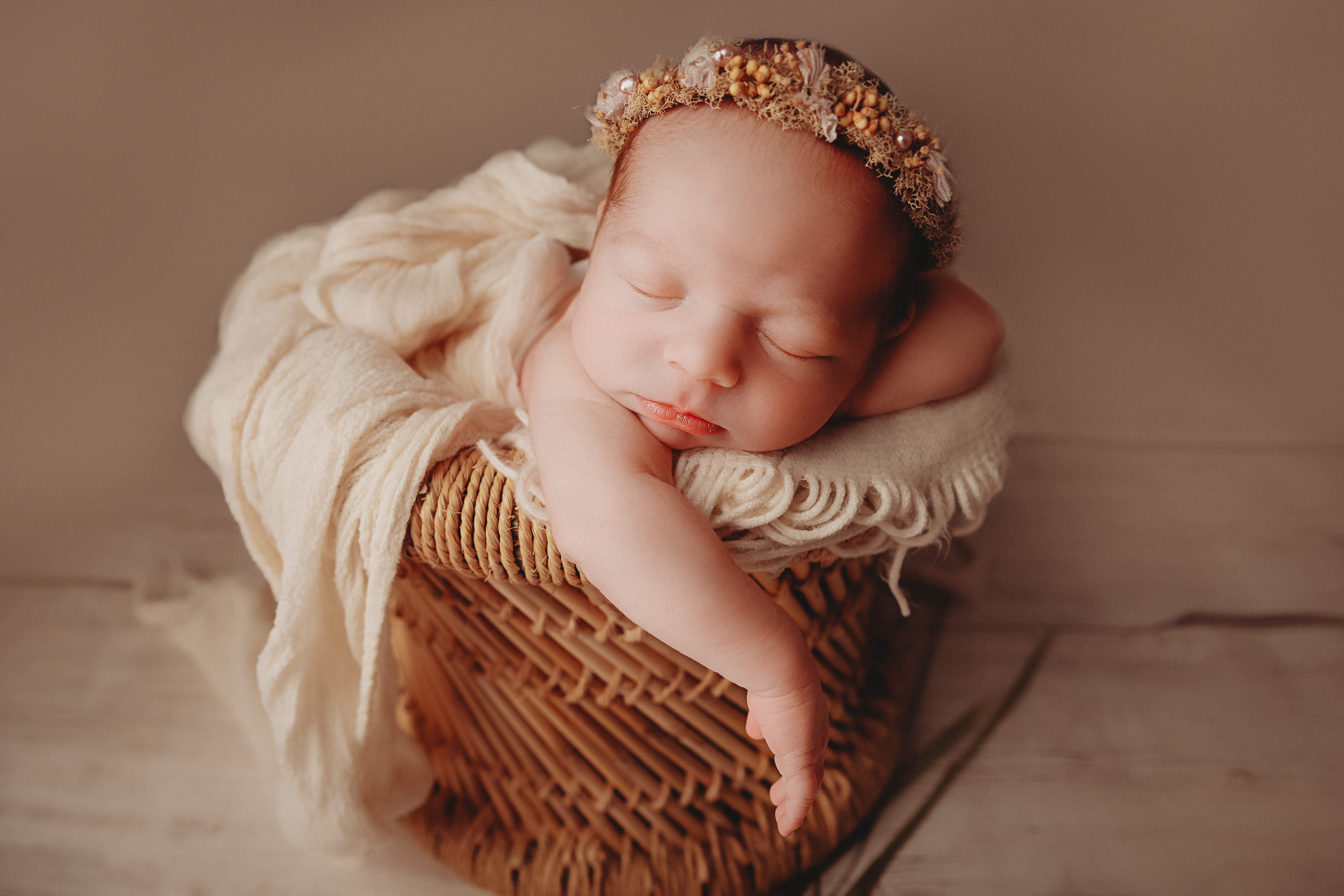 newborn girl in tall bamboo basket photoshoot cream floor