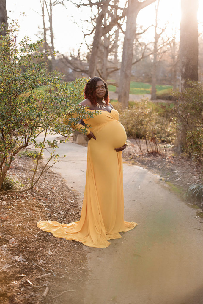 pregnant woman on pathway gold gown sunset selecting your maternity photographer