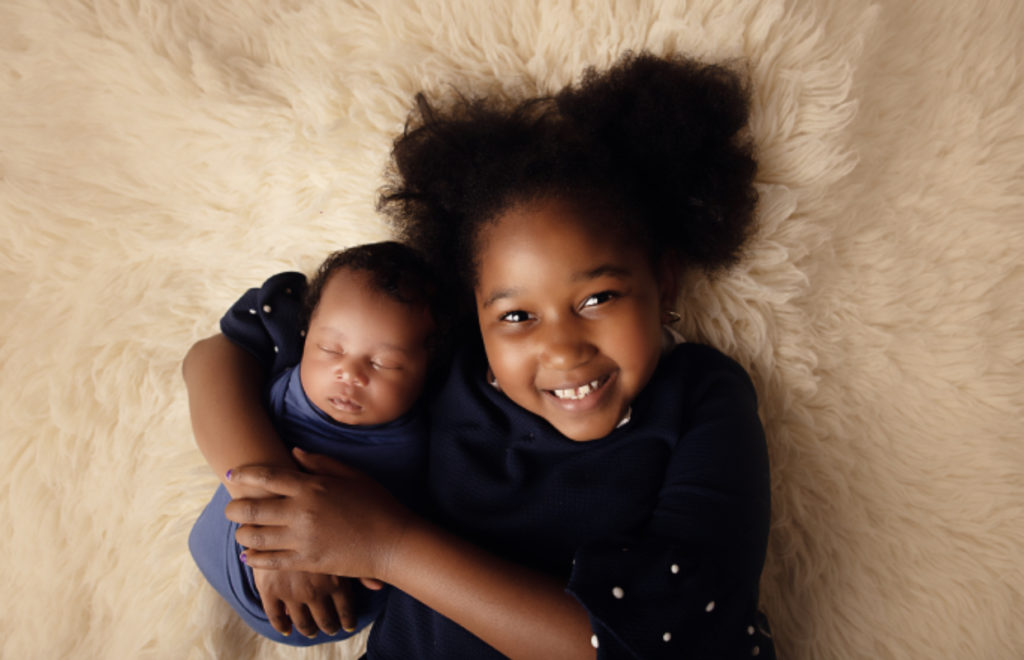 siblings at newborn session wearing blue