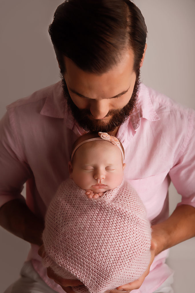 what to wear for newborn session new dad holding daughter pink button down