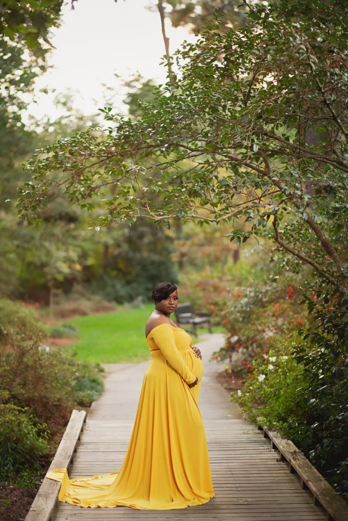 pregnant woman standing on wooden pathway